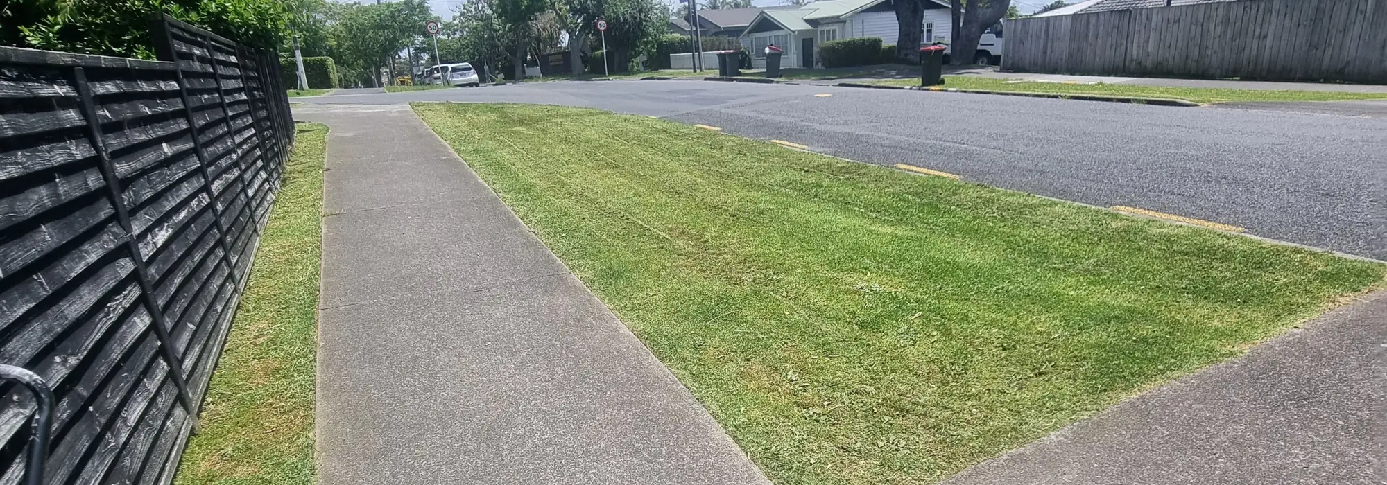 A mown street berm and footpath on a South Auckland street