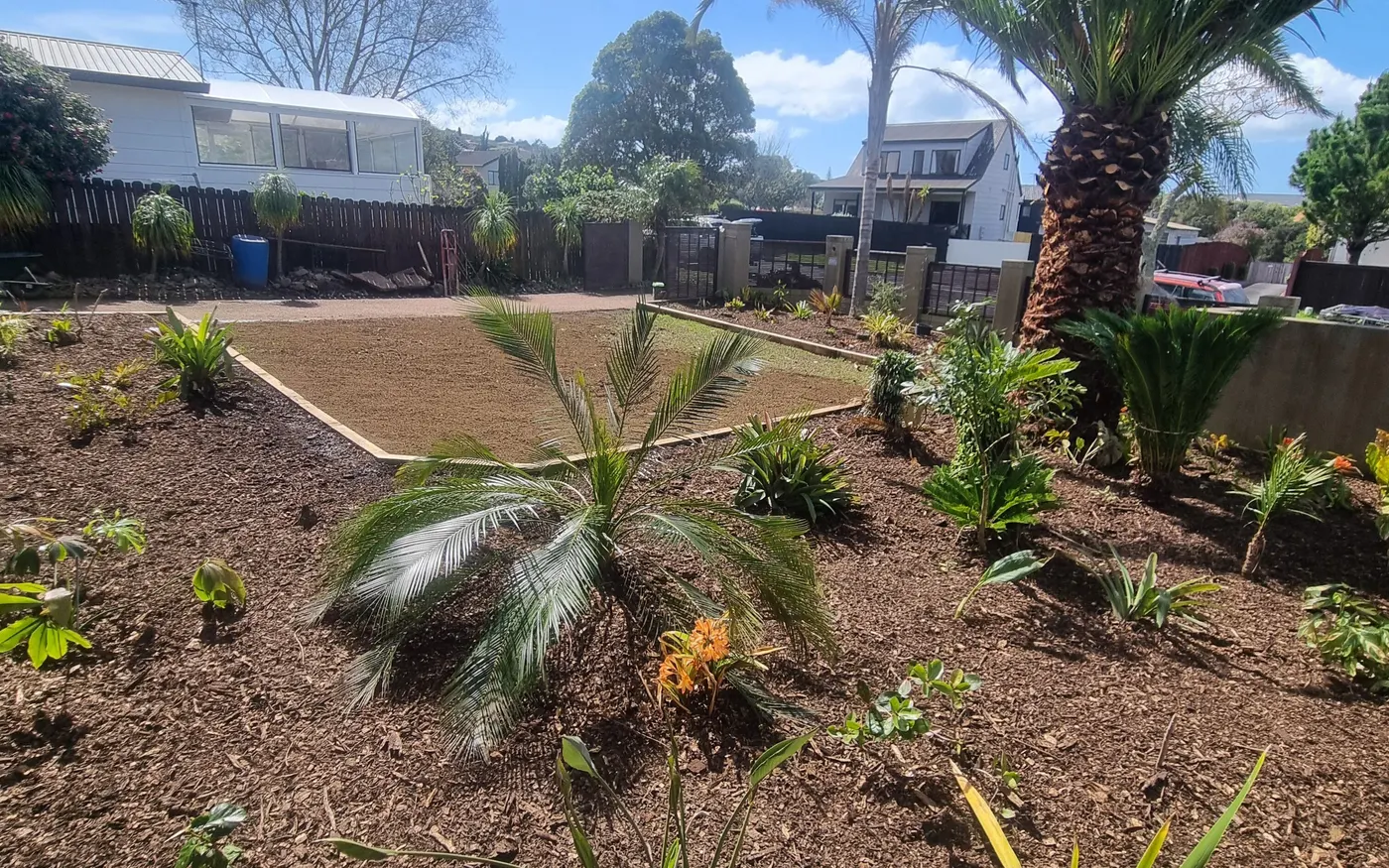 A cleared and gravelled garden bed under a deck