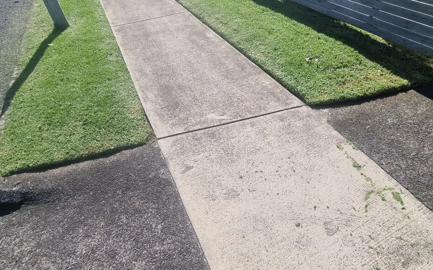 A narrow side strip with trimmed edges along a fence line