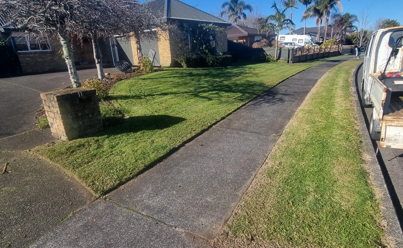 A freshly mown street berm in Papatoetoe with the edges cut in along the footpath by 0-Nine Lawn Care