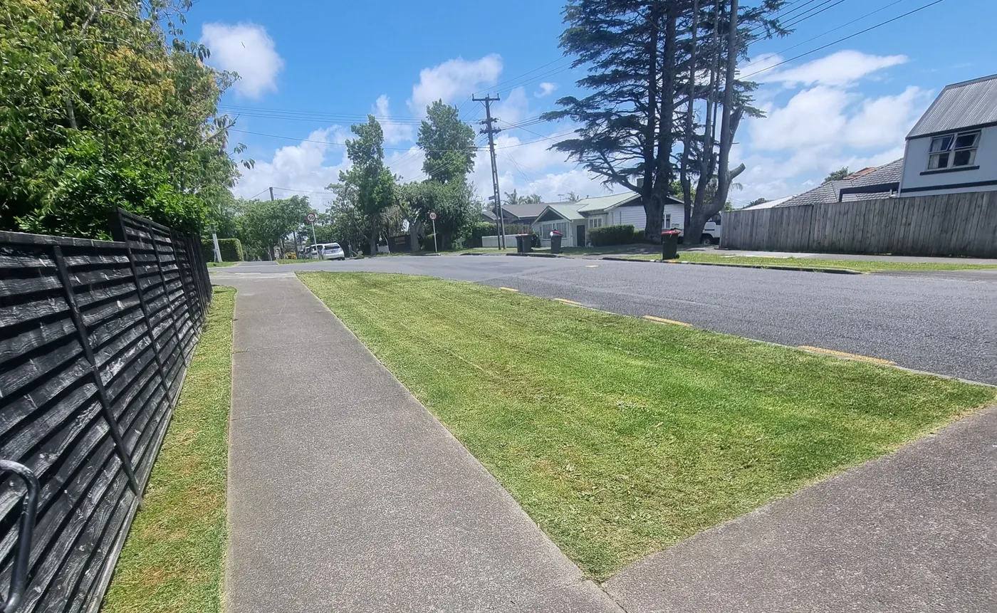 A mown street berm and footpath on a South Auckland street, cut and edged by 0-Nine Lawn Care